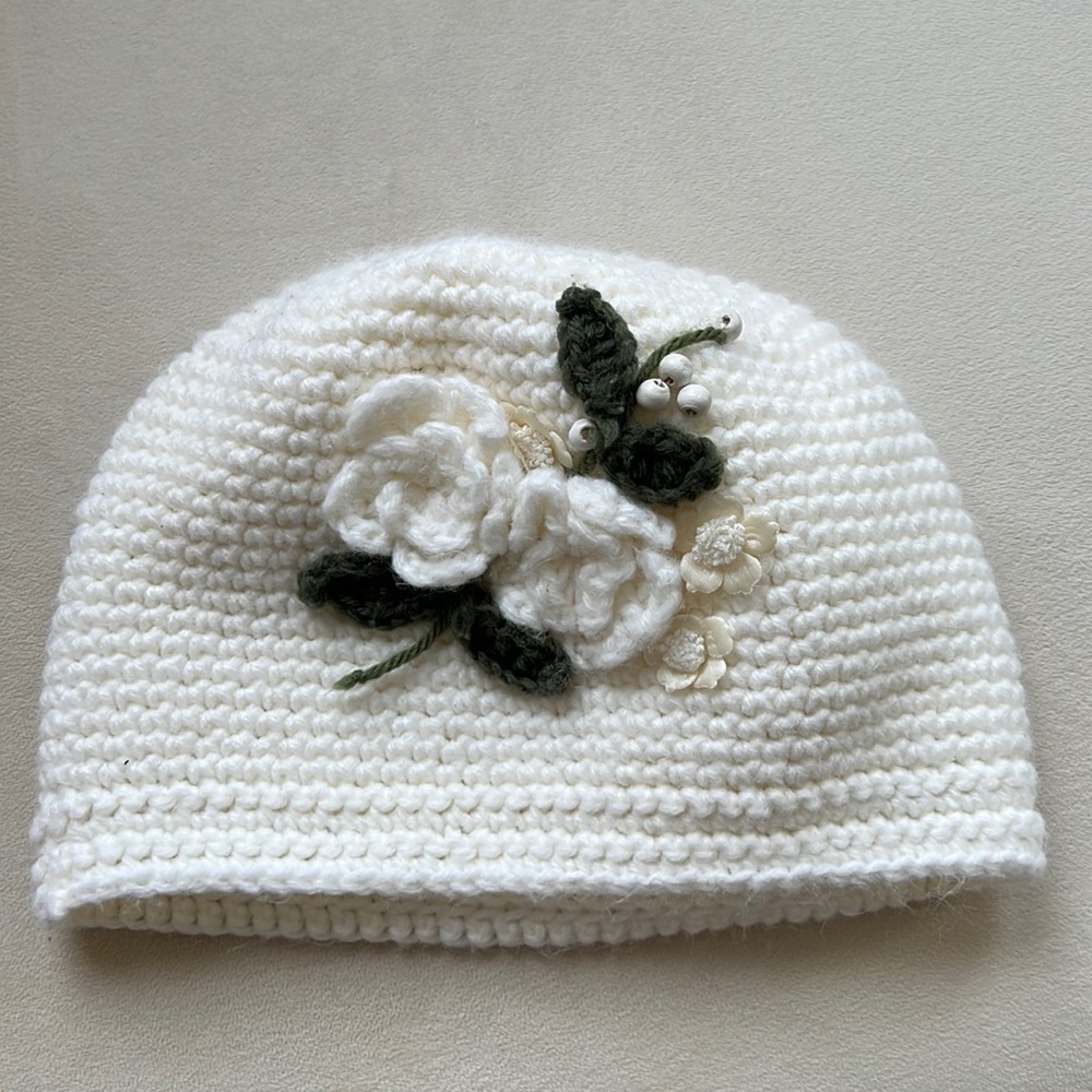Ivory Knitted hat with embroidery details.